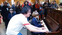 Terry Miles and an 8-year-old boy have fun playing a public piano